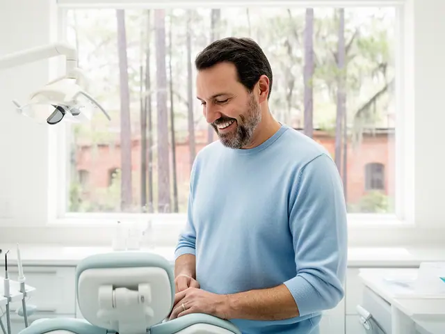 A dentist standing beside a dental chair.